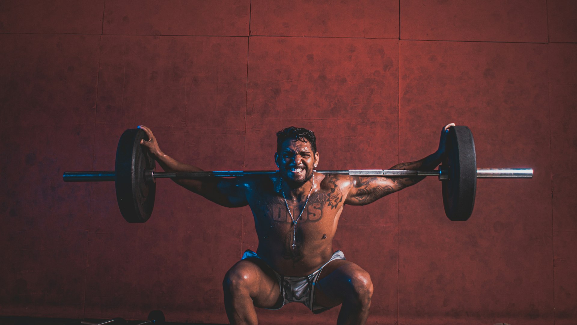 A member locked out in an overhead squat in the training space